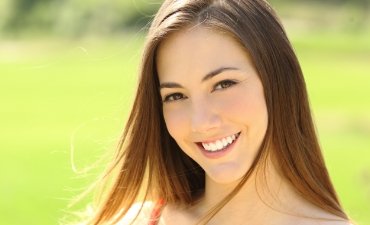 Happy young woman smiling in the sunshine - Sedation Dentistry at Meadows Dental Group