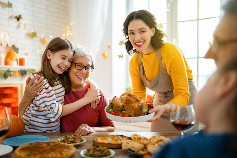 Family sitting at a table celebrating Thanksgiving
