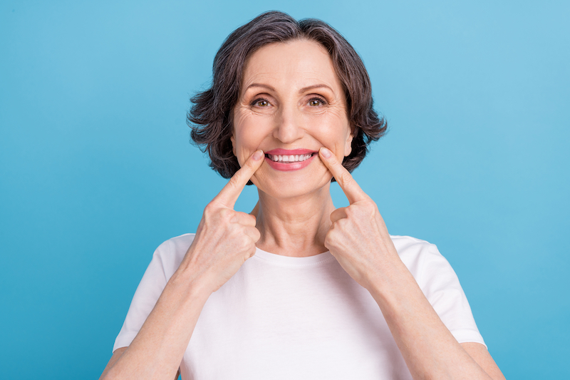 Woman smiling fingers pointing to her teeth