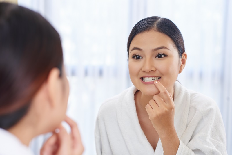 Woman checking her teeth in Lone Tree